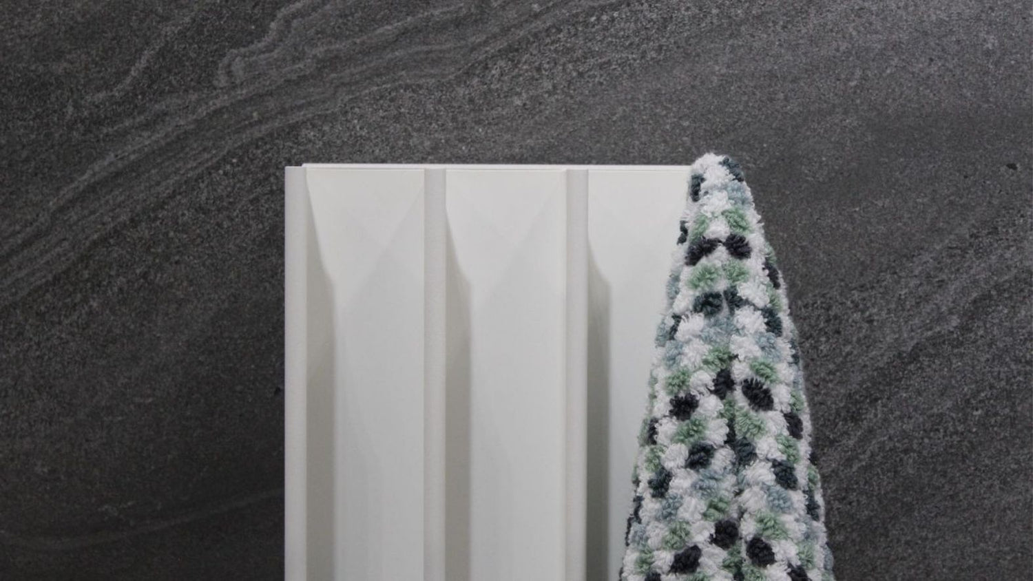 White gordon electric towel warmer on slate wall